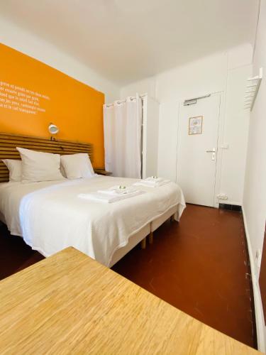 a bedroom with two beds and an orange wall at Villa TerraMera Hôtel in Le Lavandou
