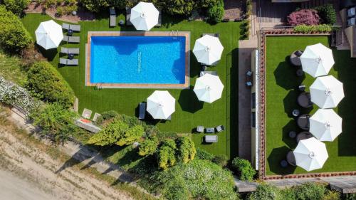 una vista aérea de una piscina con sombrillas blancas en Hotel Costabella en Girona