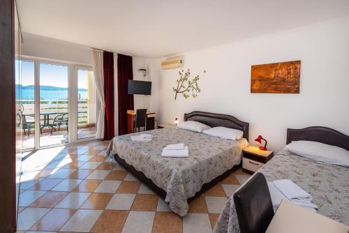a bedroom with two beds and a balcony at Villa Sunce in Sukošan