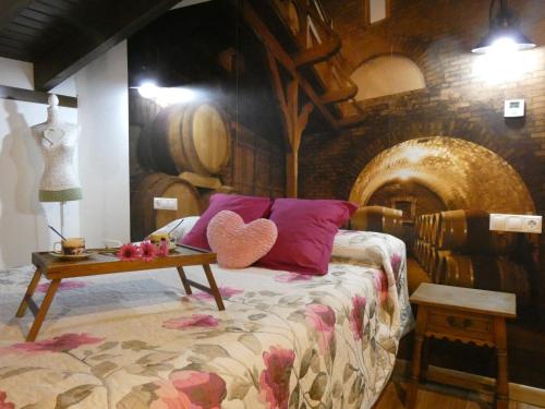 ein Schlafzimmer mit einem Bett mit einem Tisch und Weinfässern in der Unterkunft Lagar I con JACUZZI in Curiel de Duero