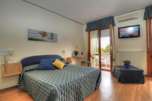 um quarto com uma cama e uma televisão na parede em Al Cavallino Bianco em Lignano Sabbiadoro