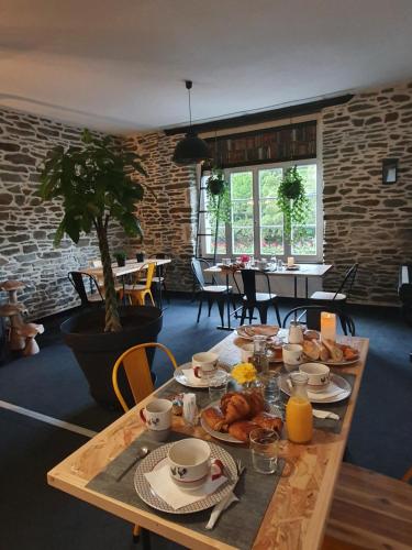 a wooden table with breakfast food on it in a room at Aux Lits du Canal in Josselin