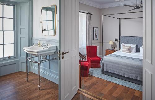 a bathroom with a sink and a bedroom with a bed at Moonfleet Manor Hotel in Weymouth