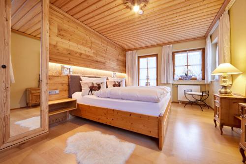 ein Schlafzimmer mit einem großen Bett in einem Holzzimmer in der Unterkunft Regina in Garmisch-Partenkirchen
