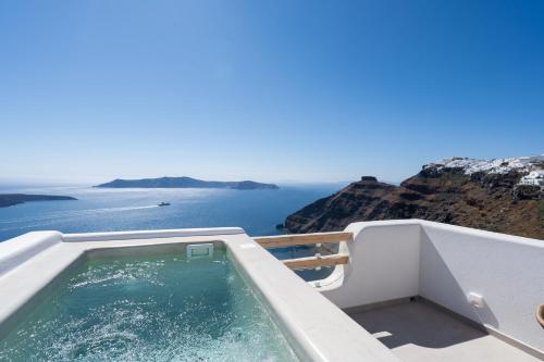 a swimming pool with a view of the ocean at Airth Santorini Suites in Firostefani