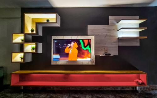 a television on a wall with a red bench at Affordable Hyswan Family Guesthouse in Krugersdorp