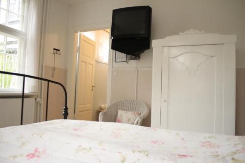 a bedroom with a bed and a tv on the wall at Hotel Egeskoven in Viborg