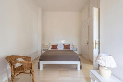 Un dormitorio blanco con una cama y una silla. en Ulivo, en Monopoli