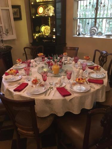 une table avec une nappe blanche, des assiettes et des verres dans l'établissement La Perla Hotel Boutique B&B, à Guadalajara