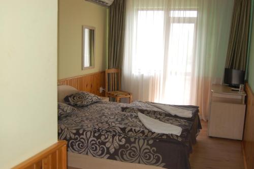 um quarto de hotel com uma cama e uma janela em Хотел Варненци em Lŭki