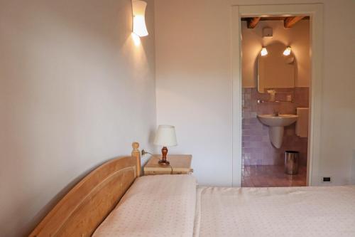 a bedroom with a bed with a sink and a mirror at Agriturismo La Bella in Follina