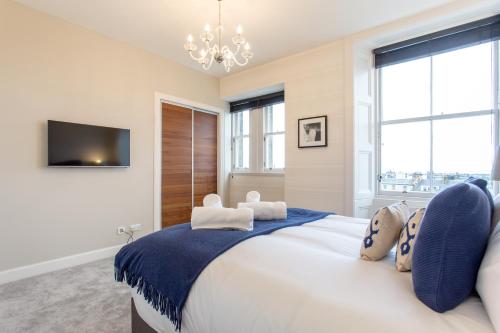 a bedroom with a large bed with a chandelier at Exclusive 2 Bed, Free Private Parking, in West End in Edinburgh