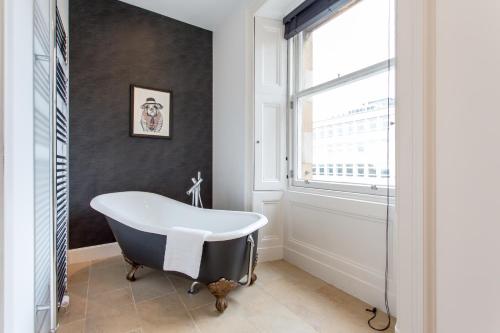 a bath tub in a bathroom with a window at Exclusive 2 Bed, Free Private Parking, in West End in Edinburgh