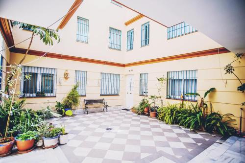 un patio con plantas y un banco en un edificio en Palacio de Dueñas Private Terrace, en Sevilla