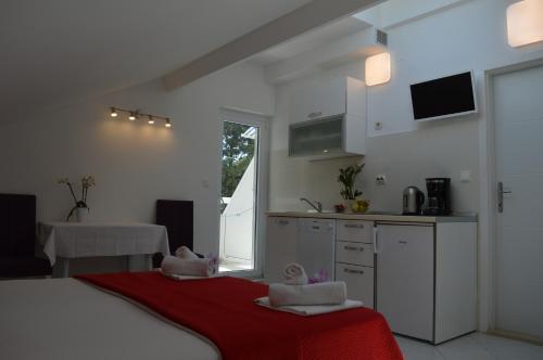 Habitación con cocina y cama con toallas. en Villa Kristonia en Hvar