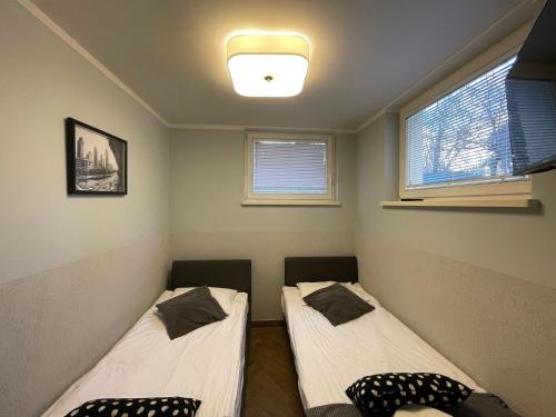 twee bedden in een kamer met twee ramen bij Platan Apartments-2 bedrooms-3 min Main Squer in Krakau