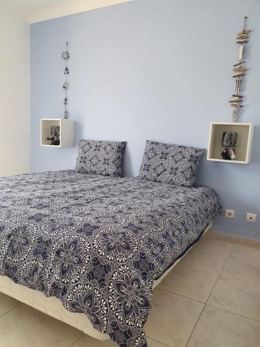 a bedroom with a bed with a black and white comforter at Brisa's Haven Guesthouse !Pet Friendly! in Lagos