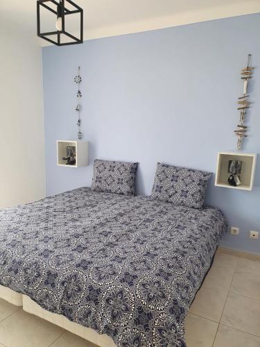 a bedroom with a bed with a blue and white comforter at Brisa's Haven Guesthouse !Pet Friendly! in Lagos