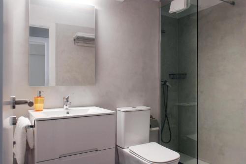 Un baño con inodoro, lavabo y ducha. en Playa América Angelito A, en Playa América