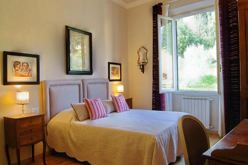 a bedroom with a bed with pink pillows and a window at Greenhouse in Florence