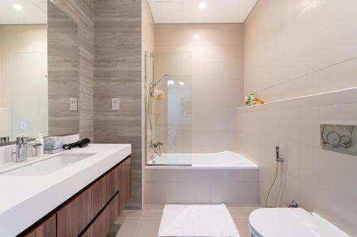 a bathroom with a tub and a sink and a toilet at Marbella Luxury 3BR & 5BR Villas at Hayat Island, Mina Al Arab in Ras al Khaimah