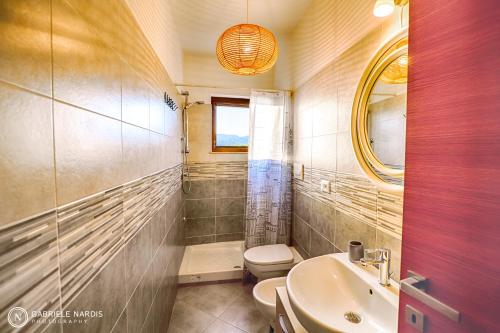 bagno con servizi igienici, lavandino e specchio di Dimora Pianello 73 - Gran Sasso a Paganica