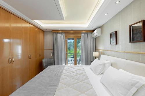 a bedroom with a large white bed in a room at Vouliagmeni's Elegance by Acropolis Suites in Athens