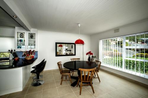 a dining room with a table and chairs at Penguinden - load-shedding free in Simonʼs Town