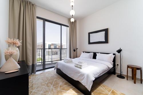 a bedroom with a bed and a balcony at Marbella Luxury 3BR & 5BR Villas at Hayat Island, Mina Al Arab in Ras al Khaimah