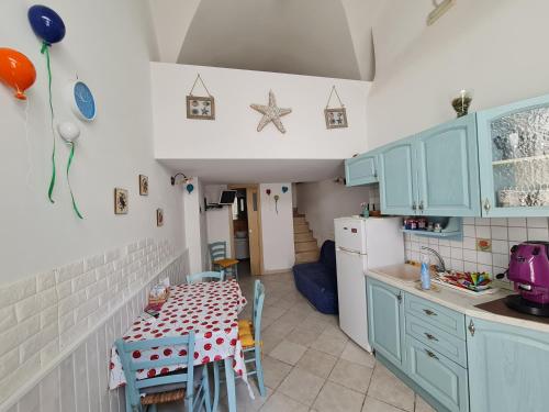 a kitchen with blue cabinets and a table with chairs at Lo scrigno dei sogni in Polignano a Mare