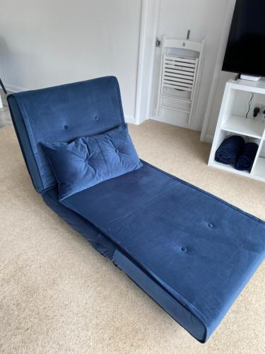 a blue couch in a room with a tv at Seabreeze in Lyme Regis