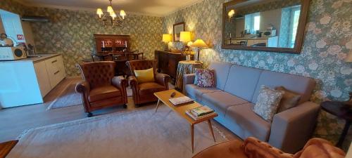 a living room with a couch and chairs and a table at Casas da Tapada Briteiros Casa das Cortes in Guimarães