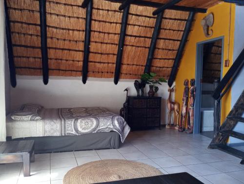 1 dormitorio con cama y techo de madera en Ifenwenzi bush Chalet, en Buffelspoort