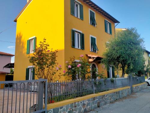 a yellow house with a fence in front of it at il Cantuccio in Lucca