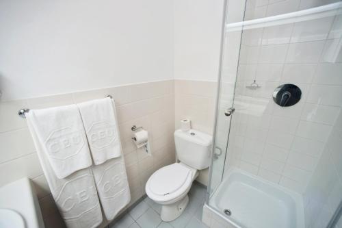 a white bathroom with a toilet and a shower at CEU Konferencia Központ in Budapest