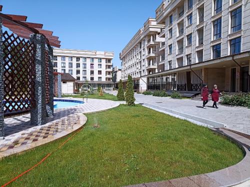 two children walking down a sidewalk next to buildings at квартира в ЦО Радуга Иссык Куль9 Raduga Issyk Kul in Chon-Sary-Oy