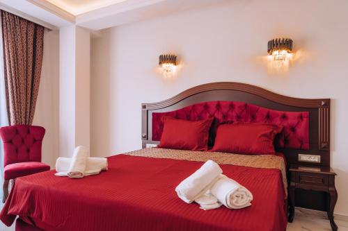 a bedroom with a red bed with towels on it at Villa Afrodita Lake View in Ohrid