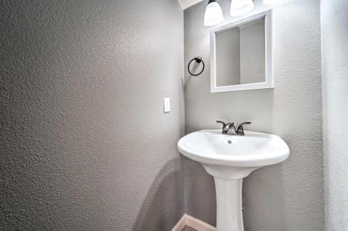 a bathroom with a white sink and a mirror at Odessa Apartment Near Parks, Shops and Dining! in Odessa