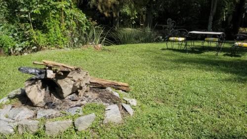 uma fogueira de pedra num jardim relvado em Casa con PILETA al borde del RIO em Benavídez