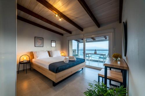 een slaapkamer met een bed en uitzicht op de oceaan bij IONIAN BLUE SUITE in Preveza
