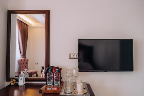 a flat screen tv hanging on a wall next to a table at Villa Afrodita Lake View in Ohrid