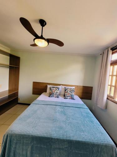 a bedroom with a bed with a ceiling fan at Casa de praia com piscina e playground in Vila Velha