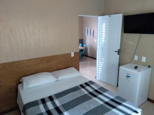 1 dormitorio con 1 cama y puerta a una habitación en Pousada Monte das Candeias en Guaramiranga