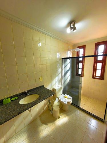 a bathroom with a toilet and a sink and a shower at Casa de praia com piscina e playground in Vila Velha