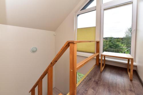 a room with a staircase and a window at Kotedžai GULBĖS TAKAS Šventojoje in Šventoji