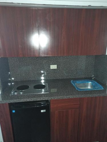 a kitchen counter with a stove and a sink at Mystic Ridge Apt 26F in Ocho Rios