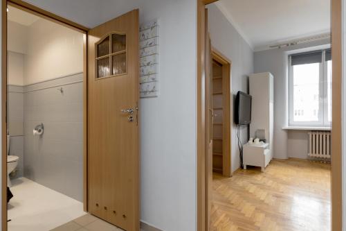 a hallway with a wooden door and a television at Grójecka Stara Ochota Apartment in Warsaw