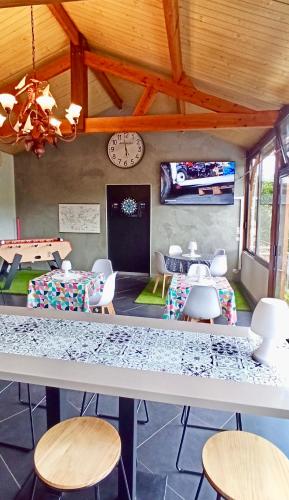 a room with tables and chairs and a clock on the wall at Résidence LE11B in Uzerche