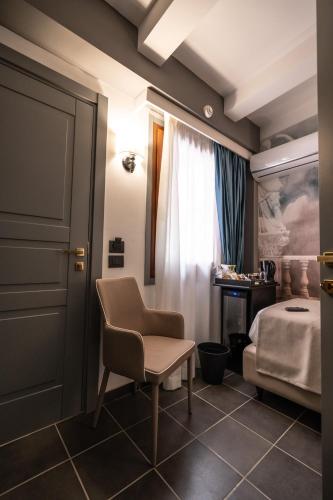 a bedroom with a bed and a chair and a desk at Relais Manzoni in Rome