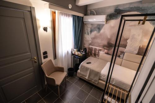 a small room with a bed and a chair at Relais Manzoni in Rome